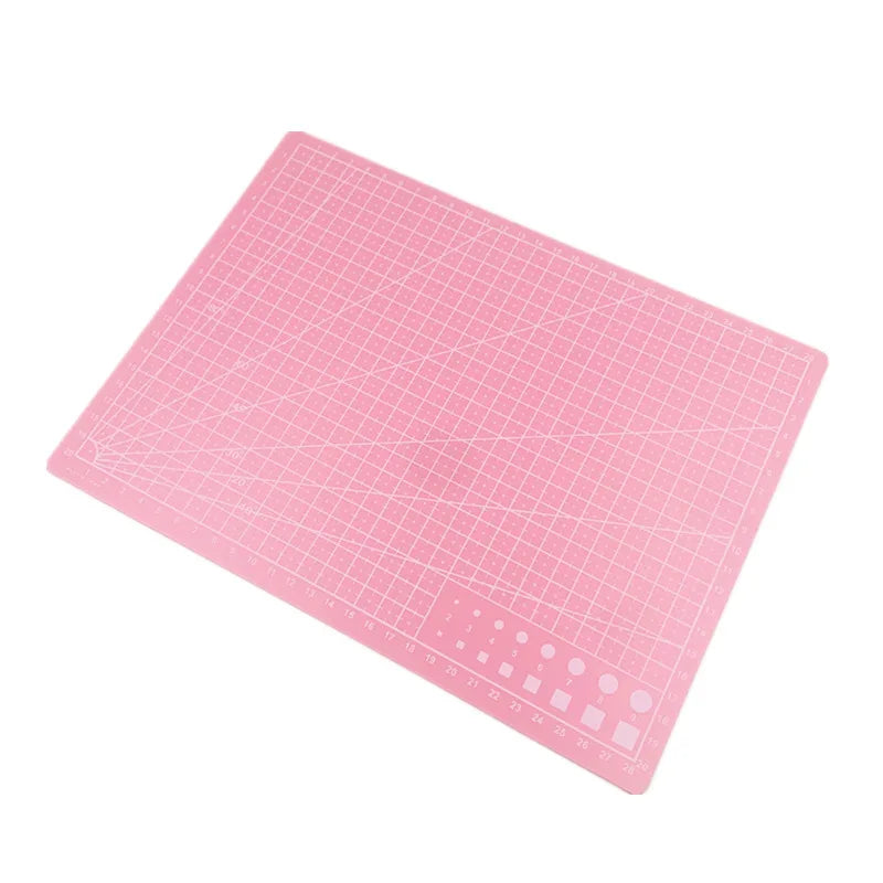 Vue d'ensemble du tapis de découpe avec cutter, règle et ciseaux