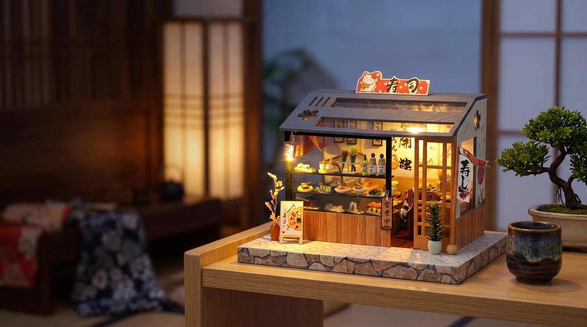 Maison miniature Échoppe à sushi montée et éclairée sur une étagère, dans un salon d'inspiration japonaise