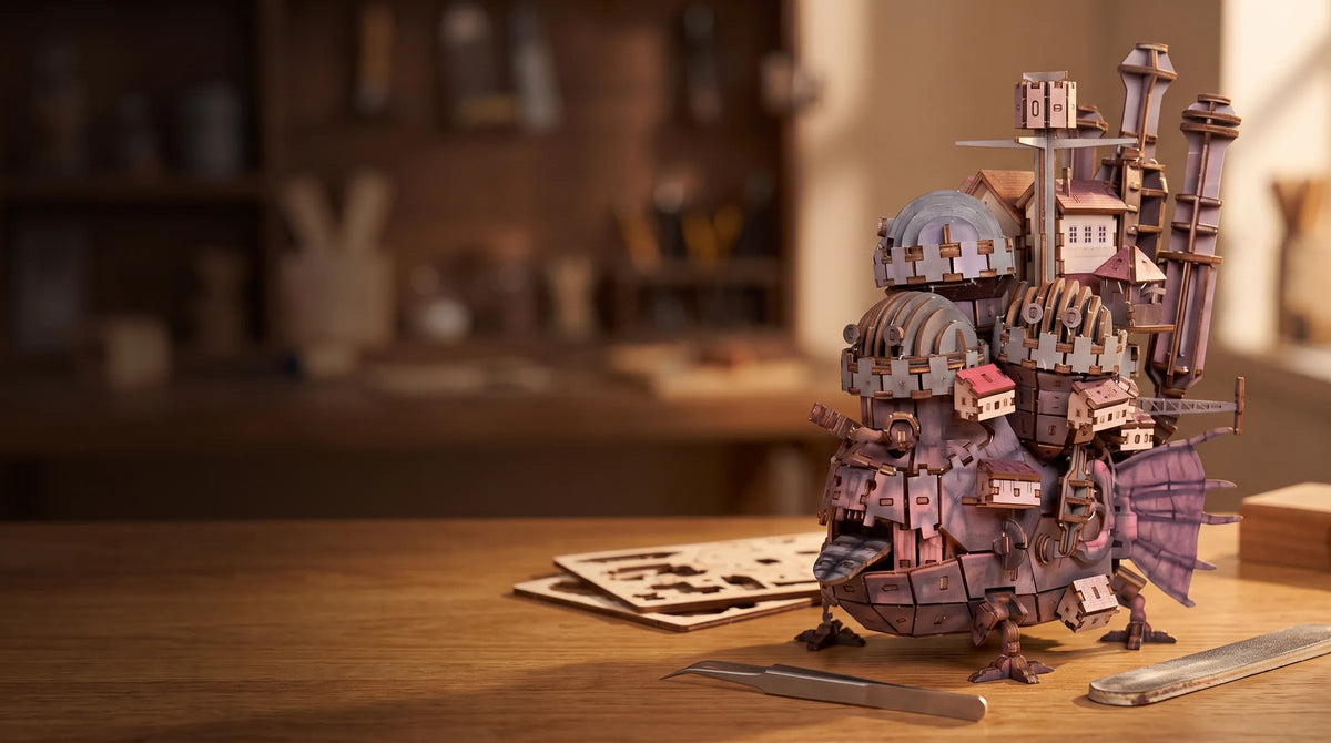 Puzzle 3D en bois du château ambulant monté sur un bureau d'atelier, avec planches et pince
