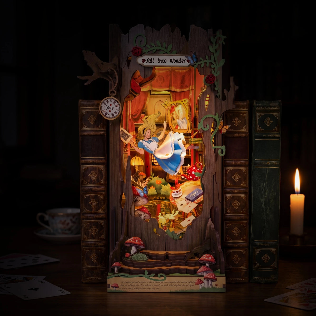 Book nook Fall into Wonder allumé la nuit à la lueur d'une bougie