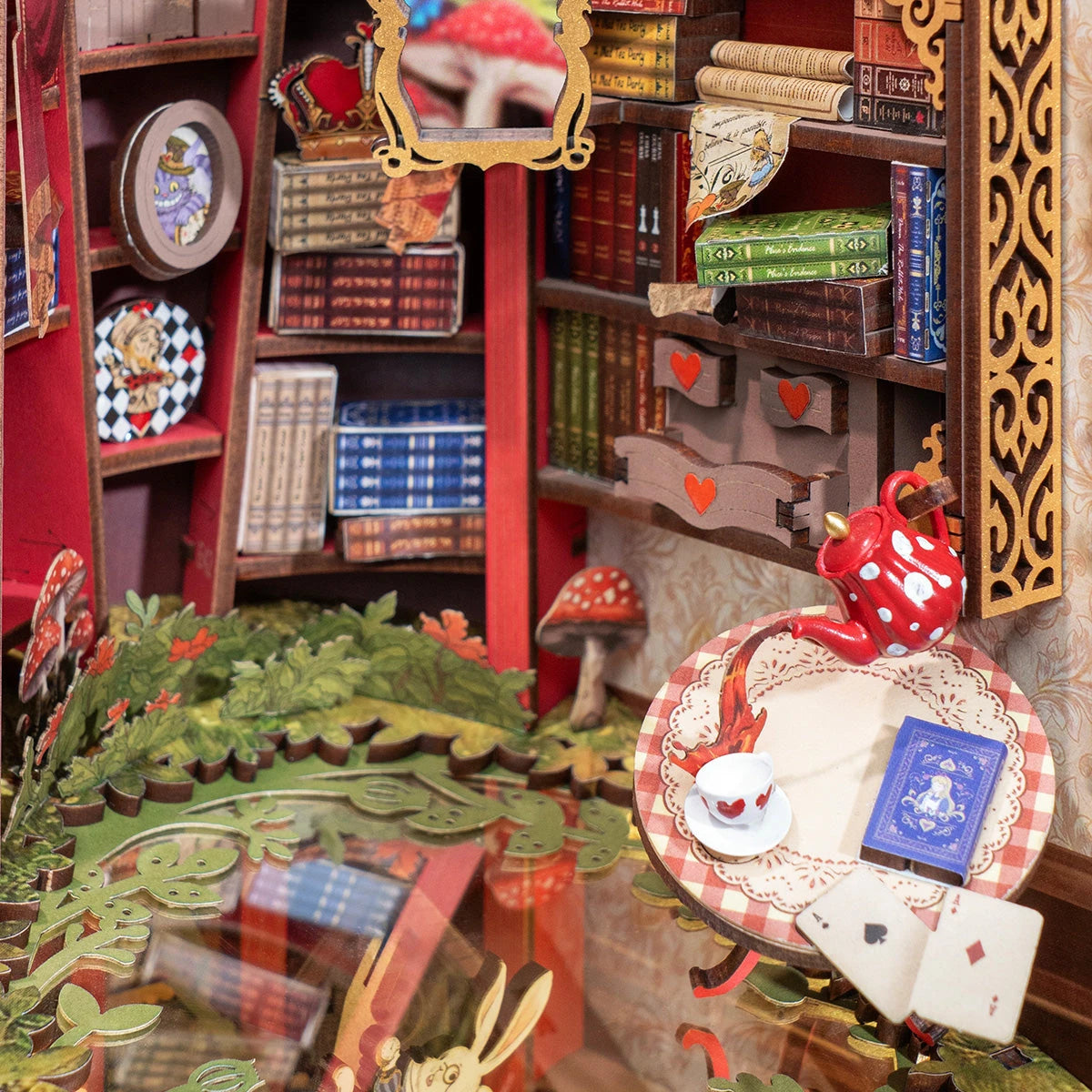 Intérieur du book nook Alice, bibliothèque rouge, théière à pois et cartes à jouer