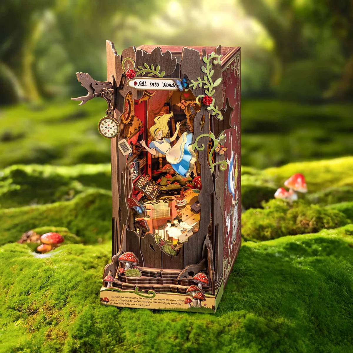 Book nook Fall into Wonder posé sur la mousse d'un sous-bois ensoleillé