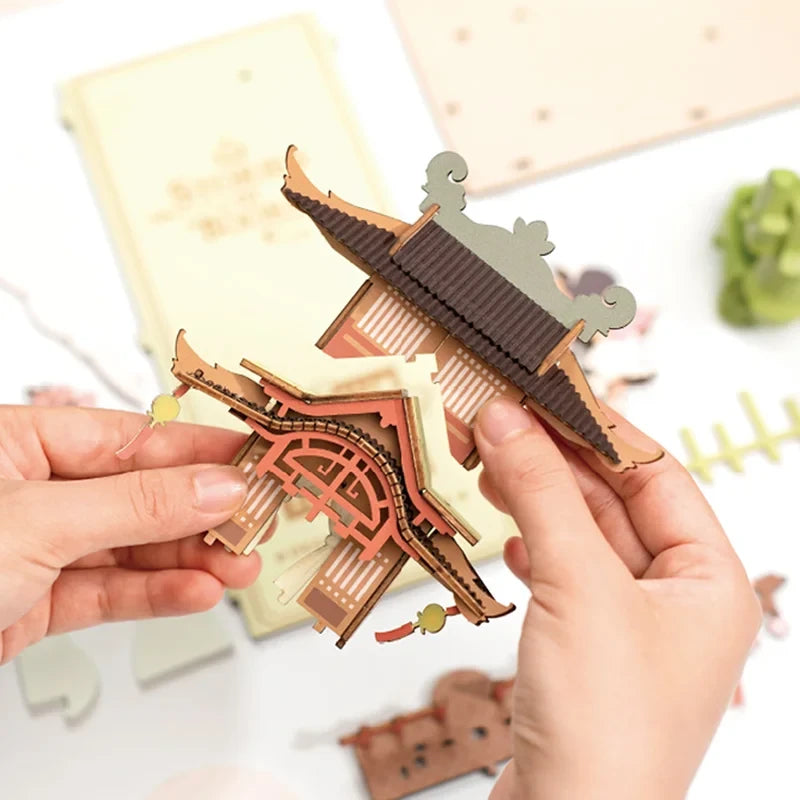 Pièces en bois précoupées du Book Nook Falling Sakura tenues en main pendant l'assemblage du toit