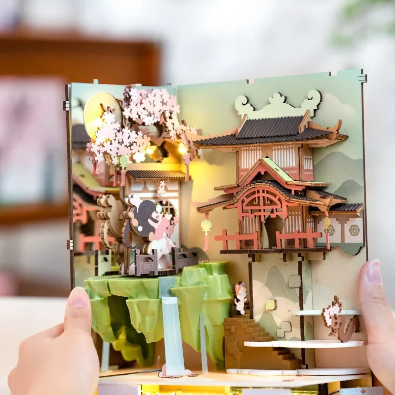 Vue intérieure dépliée du Book Nook Falling Sakura avec pleine lune, temple japonais et cascade lumineuse