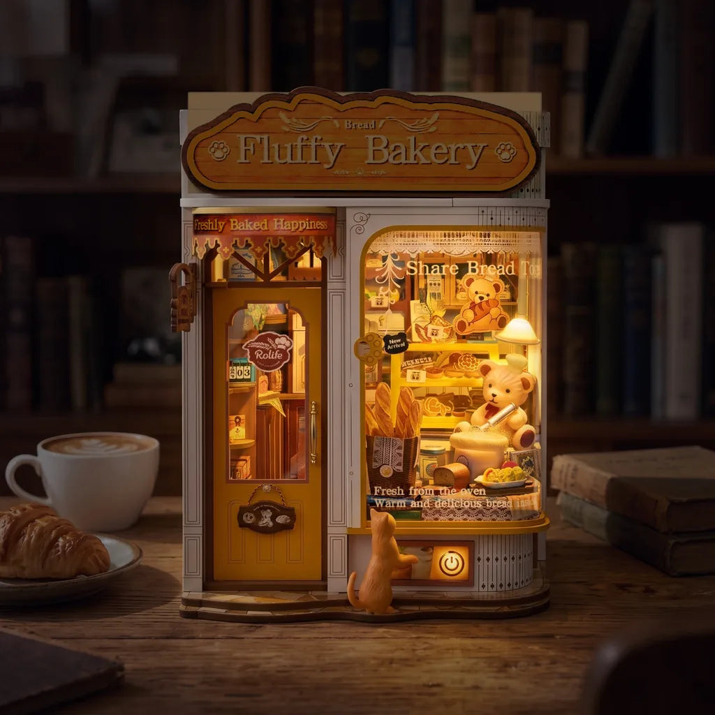 Book nook Fluffy Bakery allumé le soir, vitrine dorée et lampe du comptoir