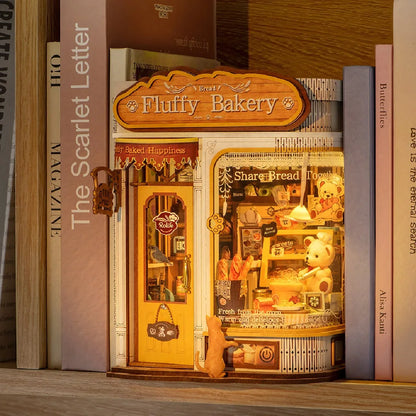 Book nook Fluffy Bakery allumé entre des livres sur une étagère