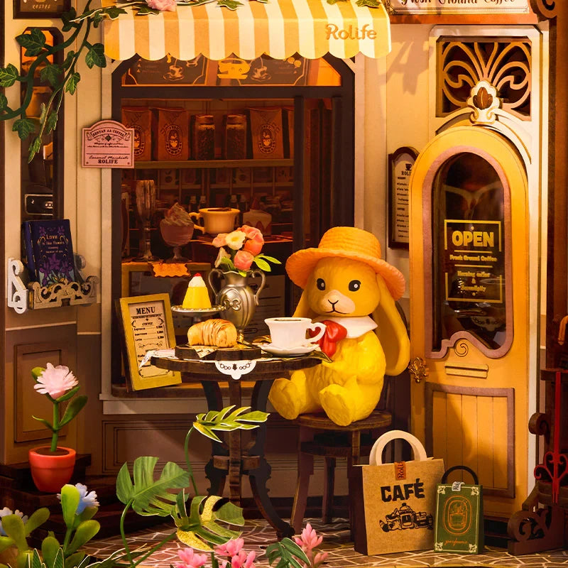 Lapin jaune en chapeau orange à sa table, croissant et café, book nook Holiday Café