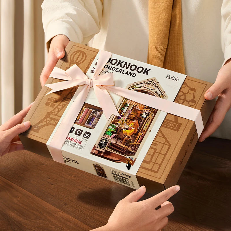 Boîte du book nook Holiday Café offerte avec un ruban rose, idée cadeau