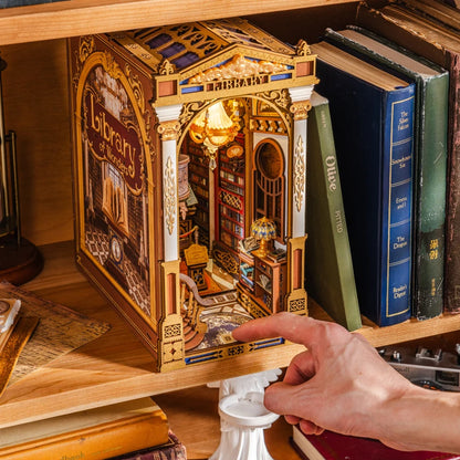 Main qui allume le book nook Library of Wonders par le bouton tactile