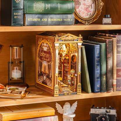 Book nook Library of Wonders sur une étagère près d'un sablier, flanc titré