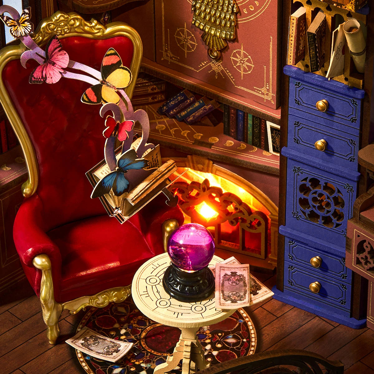 Détail du fauteuil de velours rouge, de la boule de cristal violette et de la cheminée