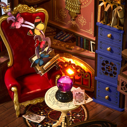 Détail du fauteuil de velours rouge, de la boule de cristal violette et de la cheminée