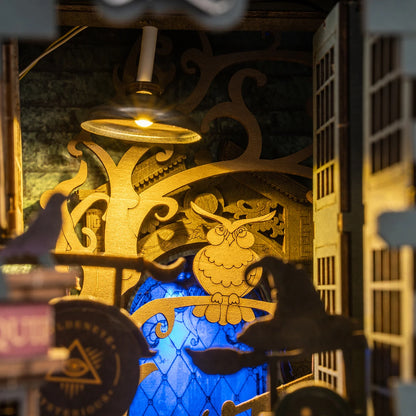 Hibou doré, chapeau de sorcière et vitrail bleu éclairés dans le book nook Magic House