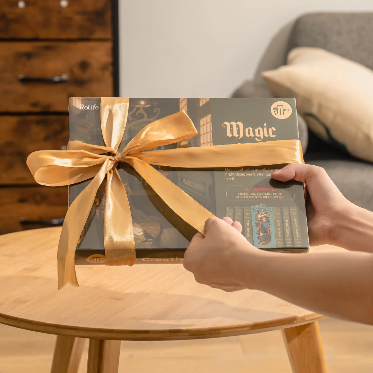 Boîte du book nook Magic House offerte avec un ruban doré, idée cadeau