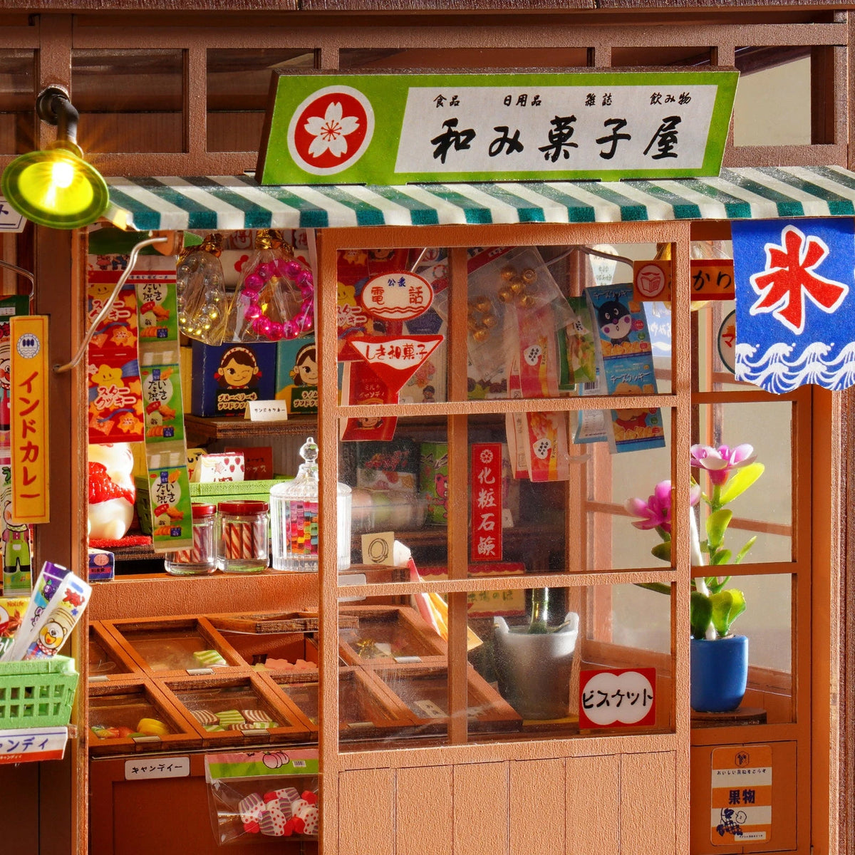 Gros plan sur la façade éclairée du book nook Nagomi Kashiya, étals de bonbons et présentoirs détaillés