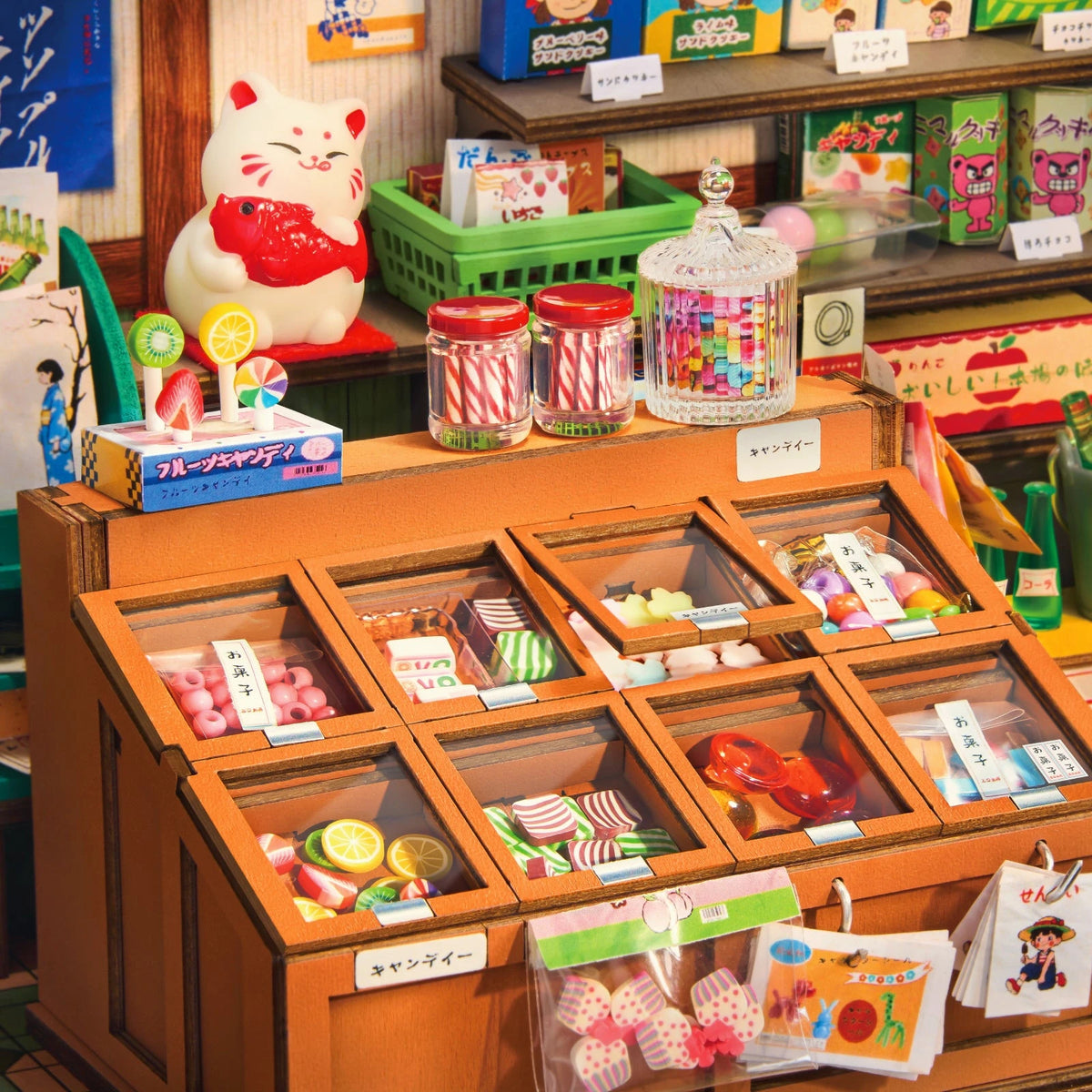Détail de l'intérieur du book nook Nagomi Kashiya, bonbons colorés et chat porte-bonheur maneki-neko