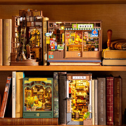 Book nook Nagomi Kashiya glissé entre des livres sur une étagère en bois