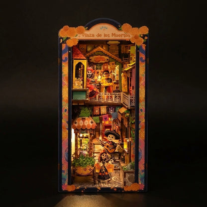 Book Nook Plaza de los Muertos éclairé de nuit, façades colorées et lanternes du Jour des Morts