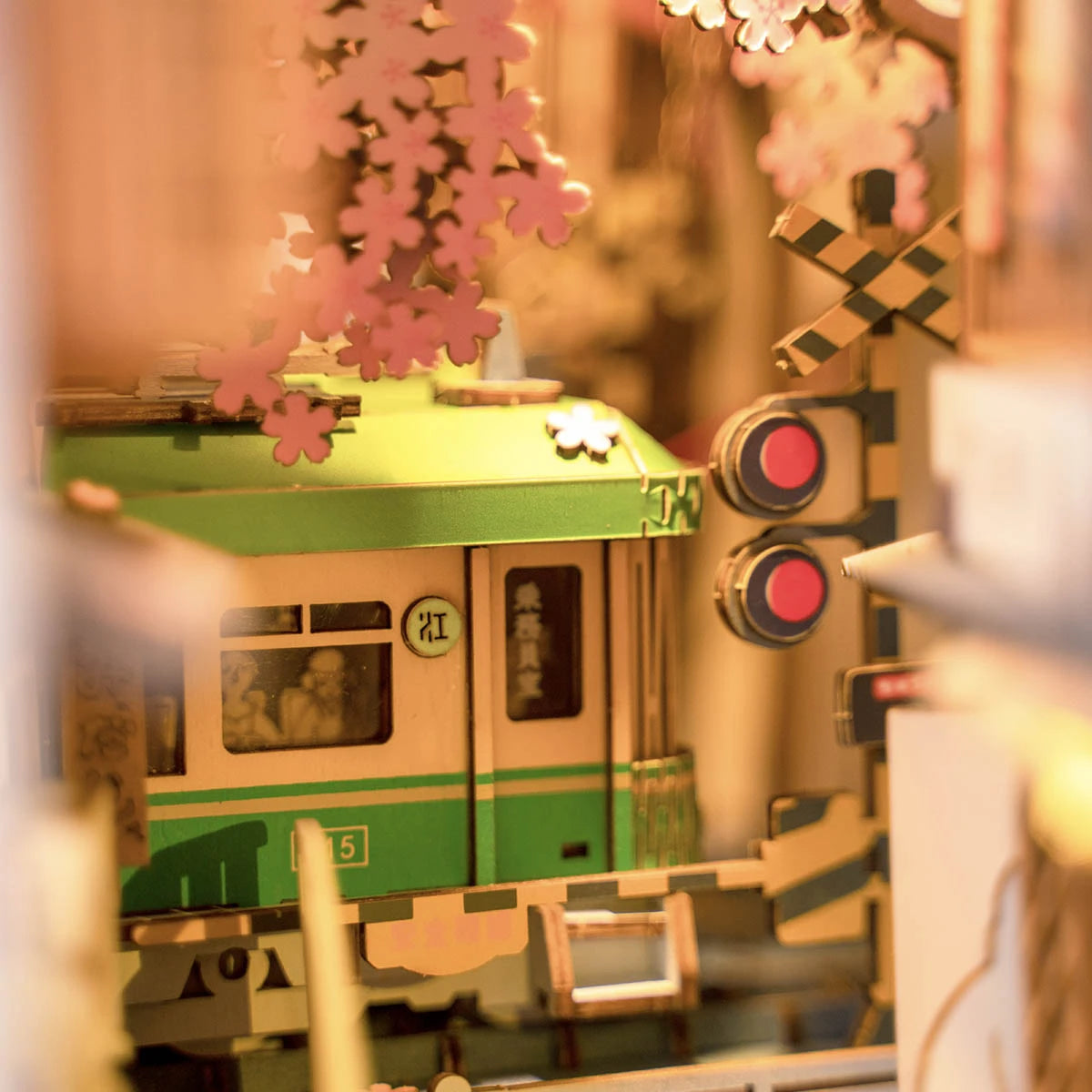 Tramway vert et crème et feux rouges du passage à niveau du book nook Sakura Densya