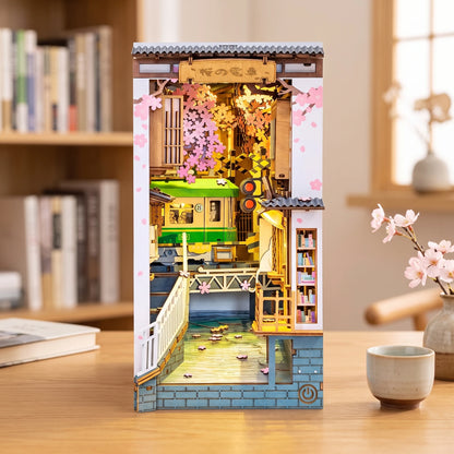 Book nook Sakura Densya allumé sur un bureau, tramway vert sous les cerisiers