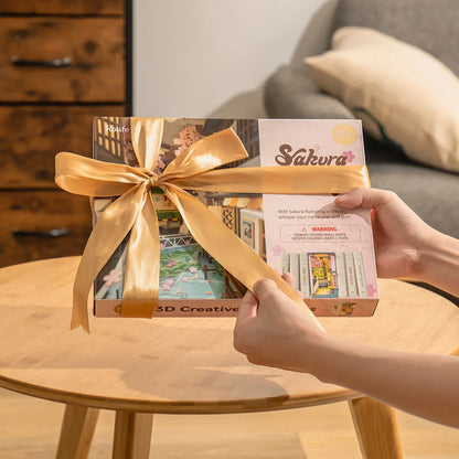 Boîte du book nook Sakura Densya offerte avec un ruban doré, idée cadeau