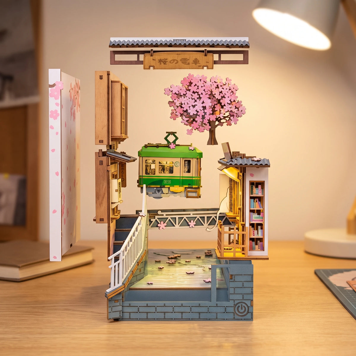 Vue éclatée du book nook Sakura Densya : tram, cerisier, pont, escalier et socle