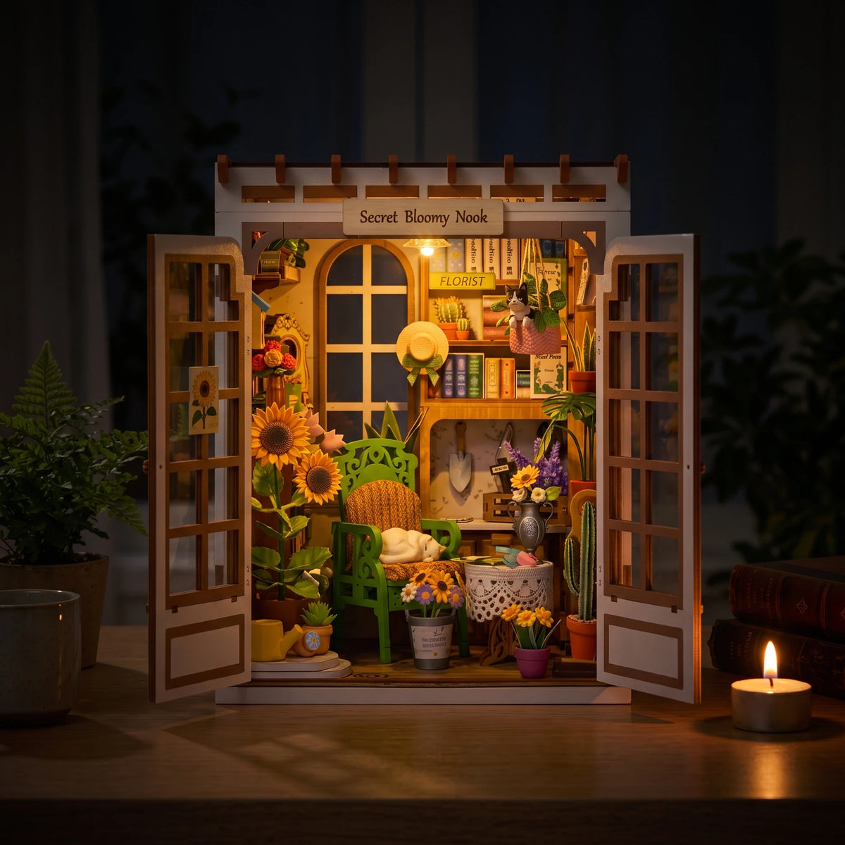 Book nook Secret Bloomy Nook la nuit, LED allumée et bougie sur le bureau