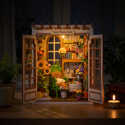 Book nook Secret Bloomy Nook la nuit, LED allumée et bougie sur le bureau