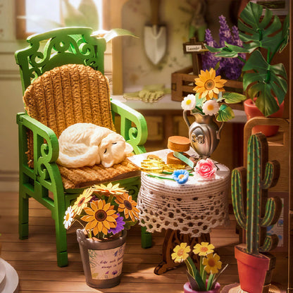 Détail du chat blanc endormi sur la chaise verte du Secret Bloomy Nook