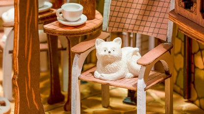 Petit chat blanc couché sur une chaise dans le book nook Sunshine Town