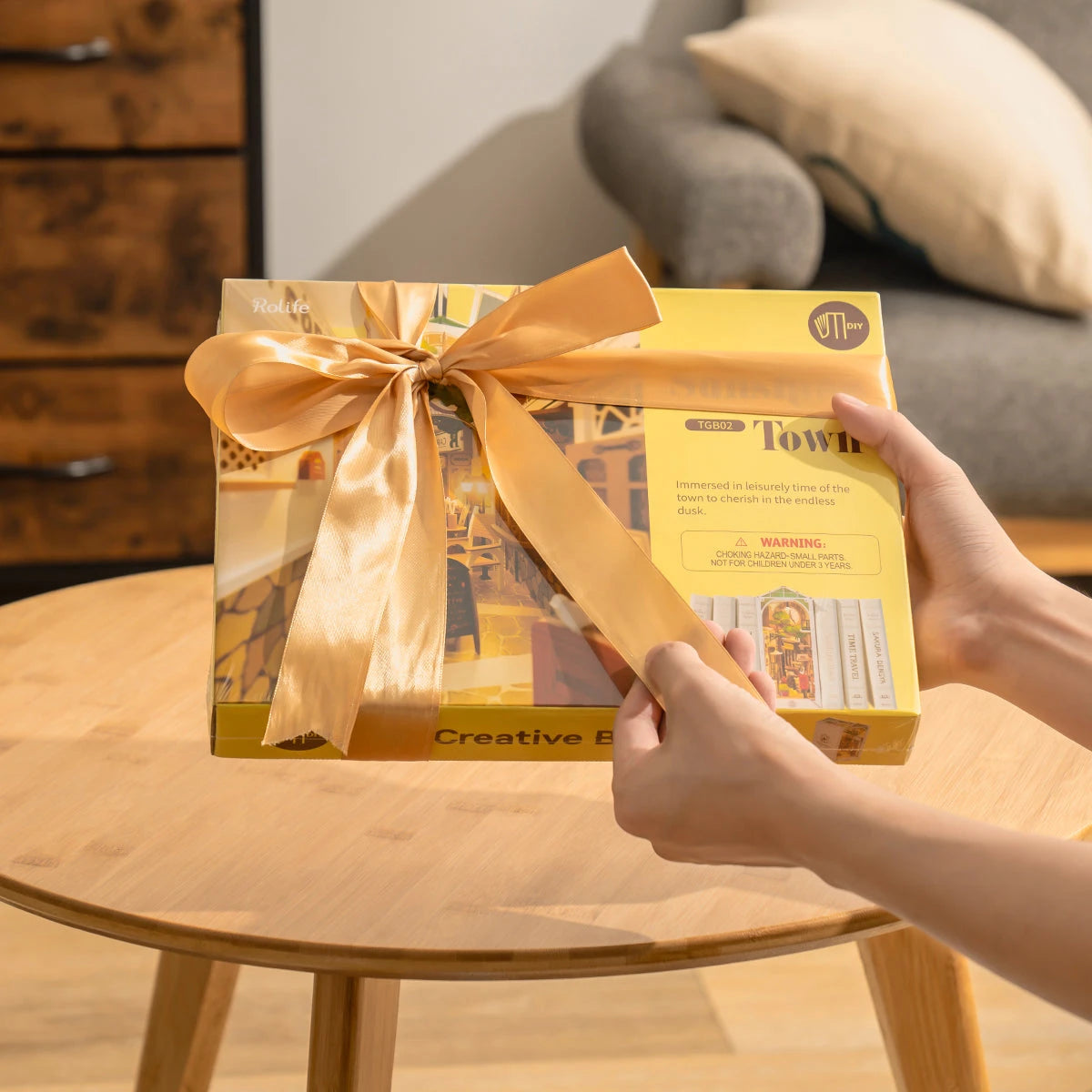 Boîte du book nook Sunshine Town offerte avec un ruban doré, idée cadeau