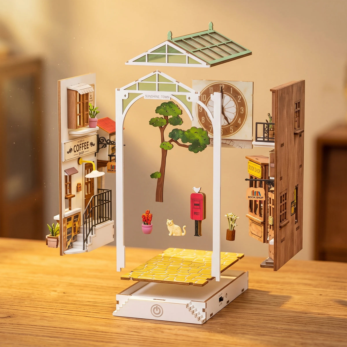 Vue éclatée du book nook Sunshine Town : cadre, verrière, horloge, café et librairie
