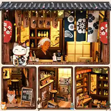 Maison miniature japonaise Taverne Bokaraka, vue détail de la devanture au noren bleu et du chat porte-bonheur maneki-neko, éclairage LED chaleureux, décoration Nook-It.