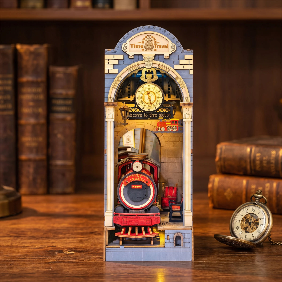 Book nook Time Travel allumé sur un bureau, locomotive rouge sous l'horloge de la gare