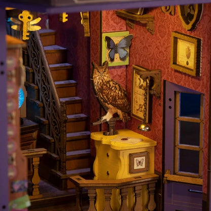 Hibou sur sa commode jaune et escalier du book nook Whisper Magic Shop