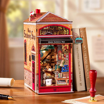 Book nook papeterie Wisdom Stationery Shop de trois quarts sur un bureau entre deux livres