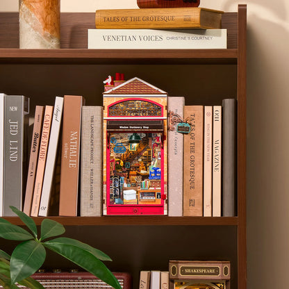 Book nook Wisdom Stationery Shop glissé entre des livres sur une étagère en bois