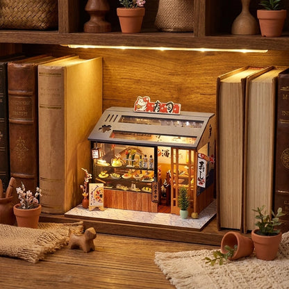 Échoppe à Sushi miniature en bois installée sur une étagère entre des livres, ambiance book nook