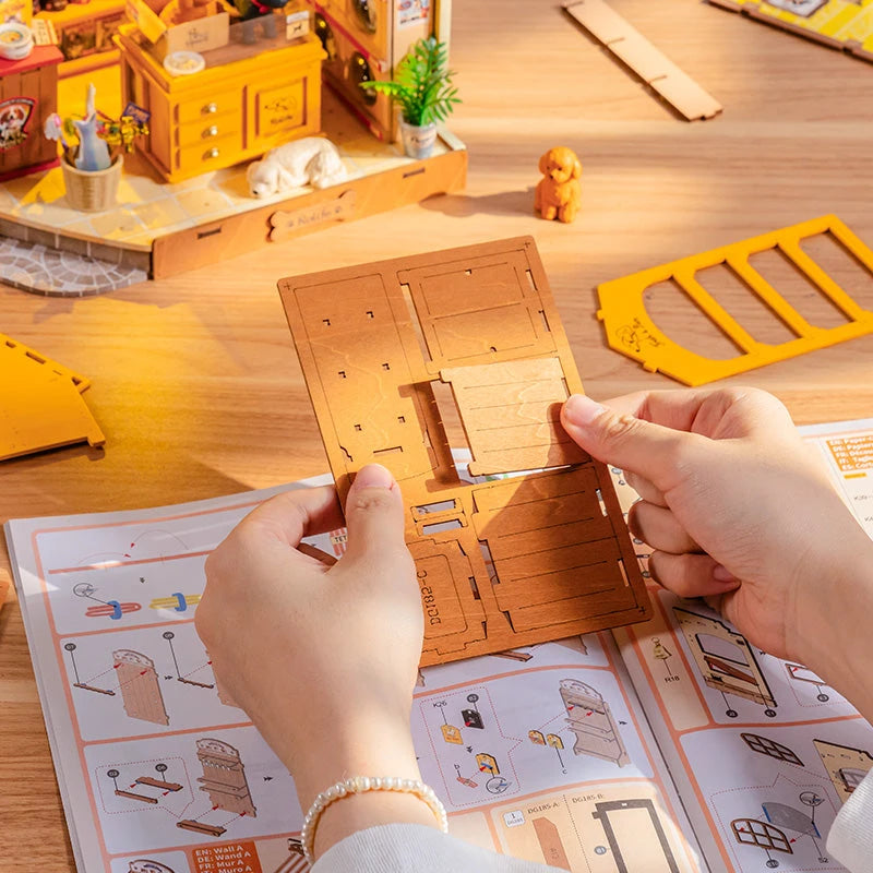Étape de montage de la maison miniature Fluffy Pets avec notice illustrée et pièces bois