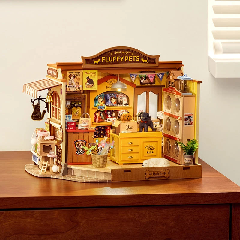 Maison miniature Fluffy Pets posée sur un bureau en bois à la lumière du jour