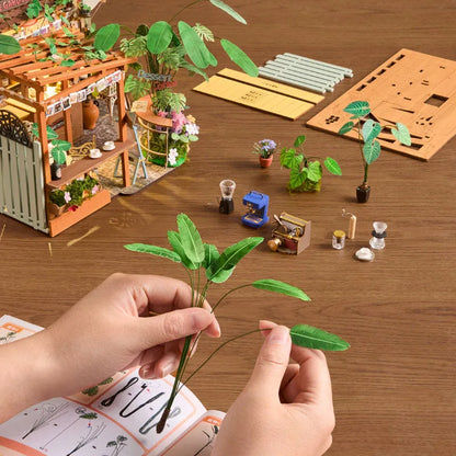 Mains façonnant une plante miniature pendant le montage du Leafree Café