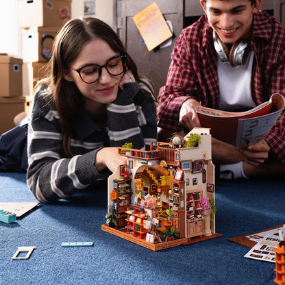 Deux amis assemblant la maison miniature Pagestory Books sur un tapis