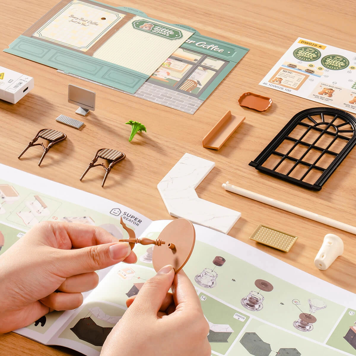 Contenu du kit Perfect Romance Café avant montage : murs, mobilier miniature et notice illustrée