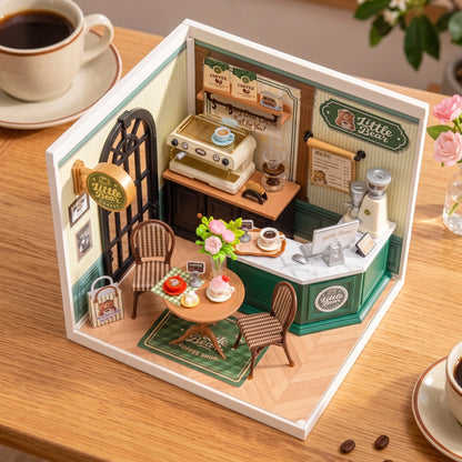 Vue plongeante dans la maison miniature Perfect Romance Café ouverte, tapis vert et table dressée