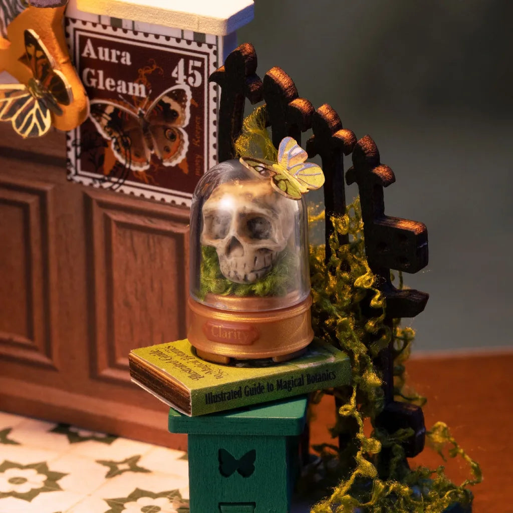 Détail du crâne sous cloche de verre sur un livre vert Potions Workshop