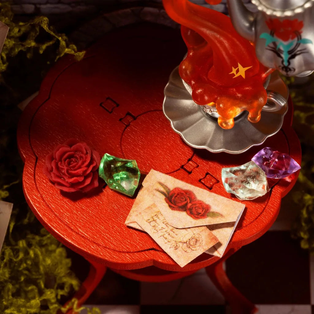 Gros plan sur la table ronde rouge avec rose, pierres précieuses et lettre