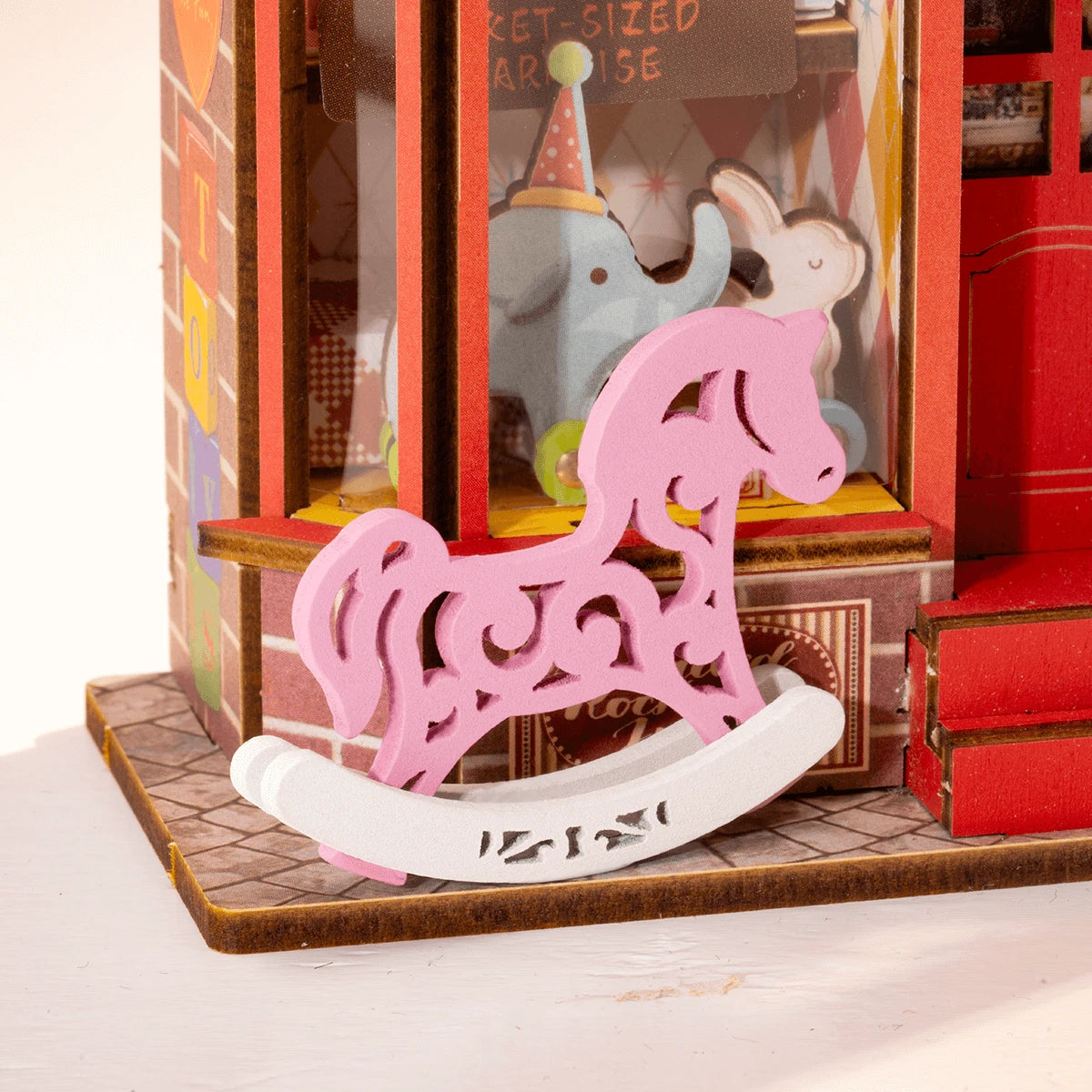 Cheval à bascule rose devant la vitrine de l'éléphant bleu, détail du Whimsy Toy Shop