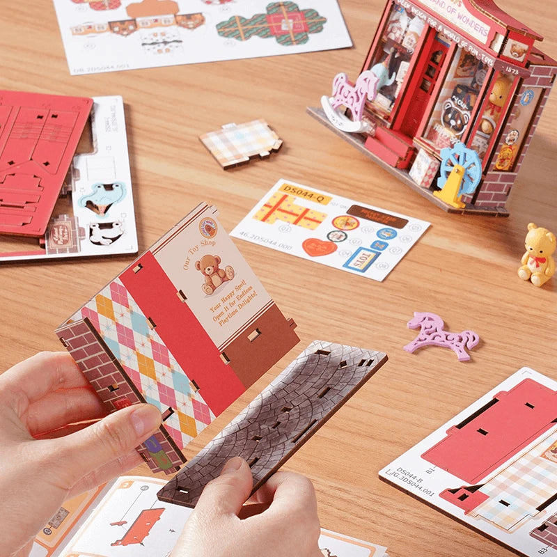 Pièces en bois imprimé du kit Whimsy Toy Shop posées sur une table pendant le montage