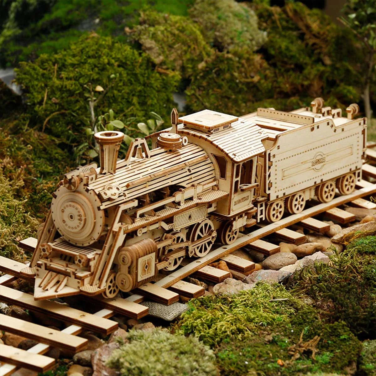 Locomotive à vapeur en bois posée sur des rails au milieu de la mousse