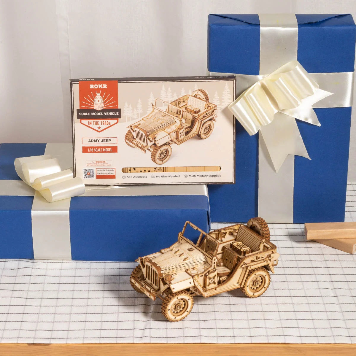 Jeep militaire en bois posée devant sa boîte ROKR et des paquets cadeaux